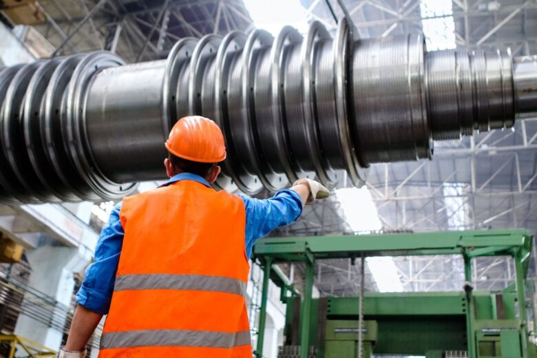 Ouvrier inspectant une grande machine industrielle dans un atelier